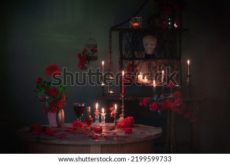 magic potion with red roses and burning candles in dark room