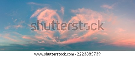 Magic real heart made from clouds in the sunset sky. Pink light heart shaped clouds. Love. Panoramic sky for Valentine's Day, Wedding, Mother's Day. Holidays of love and tenderness