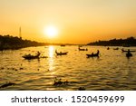 Magic and scenic view of the Buriganga river at sunset. Hundreds of boats cross the main river in Dhaka creating a scenic backlight silhouette