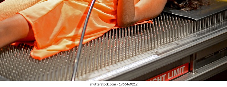 Magic Of Science. A Girl Laying On Several Nails But Nothing Is Happening To Her. It Is A Science Exhibition. 