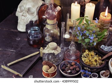 Magic Still Life With Skull, Vintage Bottles, Book, Herbs And Candles On Witch Table. Old Pharmacy, Esoteric Or Alternative Medicine Concept. Medieval Alchemist Ritual