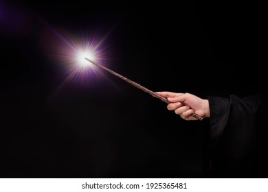 Magic wand with sparkle, Miracle magical wand stick with light sparkle. Teens hand holding a wand wizard conjured up in the air.