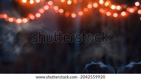 A magical background for Halloween with garlands with orange bokeh lights. Mystical night forest in all saints day. Copy space for text