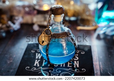 Magical blue elixir bottle secured with a small padlock, styled as an alchemical fantasy prop. Decorative potion bottle inspired by RPG, fantasy games, cosplay and LARP costumes, with mystical and gothic aesthetics.
