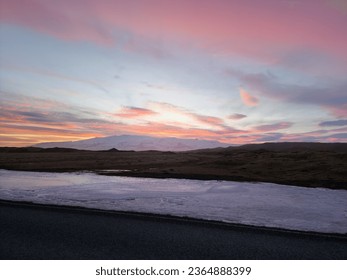 Magical cotton candy sky near frosty hills in iceland, snowy mountain chain and pastures in icelandic region. Beautiful nordic landscapes with sun setting over farmalnds, pink color. - Powered by Shutterstock