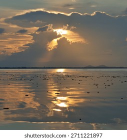 A magical dramatic sunset over a tranquil freshwater lake in Thailand.
