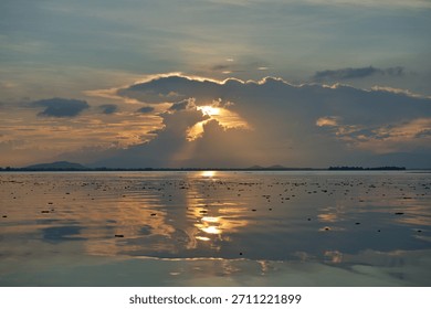 A magical dramatic sunset over a tranquil freshwater lake in Thailand.