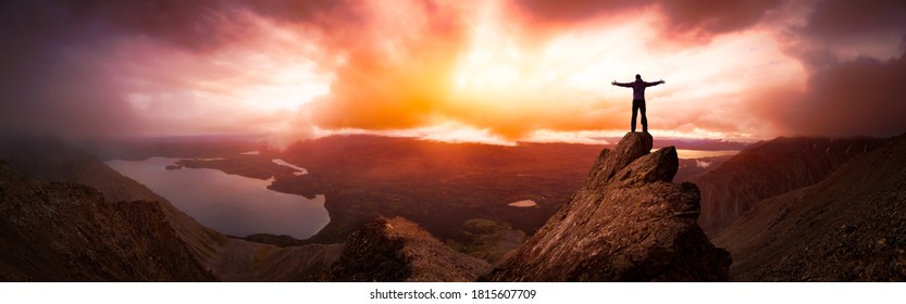 Magical Fantasy Adventure Composite of Man Hiking on top of a rocky mountain peak. Background Landscape from Yukon, Canada. Sunset or Sunrise Colorful Sky