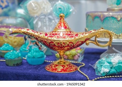 A magical lamp over a blue gradient background . Aladdin lamp of wishes on table . Aladdin's magic genie lamp in red and gold on a blue background. Antique golden colored oil lamp with rust displayed - Shutterstock ID 1965091342