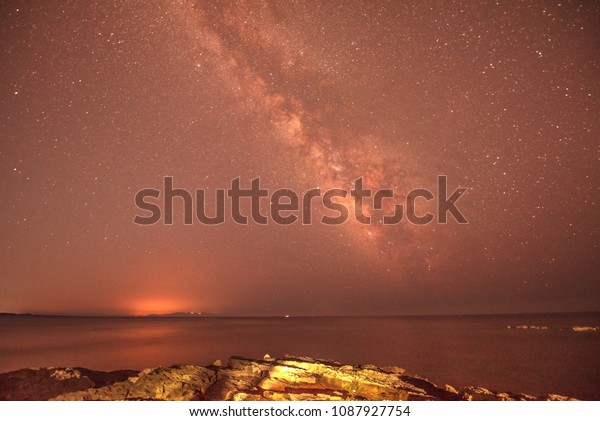 magical mystical beautiful charming landscape\
with waves and stones in the middle of the sea against the\
background of the stars and the Milky Way. (meditation, antistress,\
relaxation - concept)