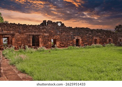 Magical sunset paints the sky red over the Jesuit ruins of San Ignacio Mini, Misiones, Argentina. An imposing historical and natural contrast.