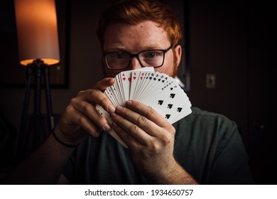 Magician Holding His Deck Of Cards Out In Front Of Him. 