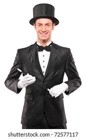 A magician holding a magic wand and posing isolated against white background