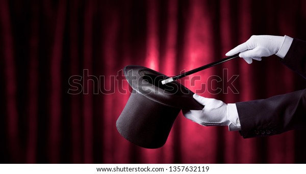 magician holding a top hat and magic wand with\
a red curtain as\
background