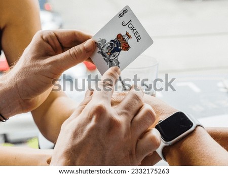 A Magician Sets Up A Magic Trick Using a Joker Card