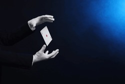 Magician Showing Trick With Card On Dark Background, Closeup. Space For Text