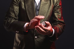 Magician Shows Trick With A Coin. Sleight Of Hand. Manipulation With Props.