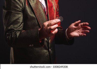 Magician Shows Trick With A Coin. Sleight Of Hand. Manipulation With Props.