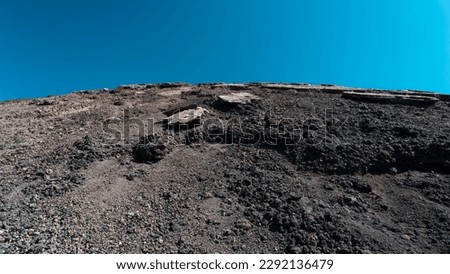 Magmatic soil and volcanic rocks. Irregularity of the ground on the slopes of a large volcano. Craters, furrows, holes and large dark rocks. Valleys of eruptive origin, desertification and drought.