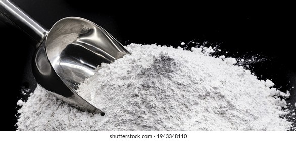 magnesium sulfate on black isolated background with metal spoon
