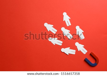 Magnet attracting paper people on red background, flat lay. Space for text