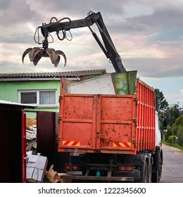 Magnet grapple picking up iron and steel metal garbage for transferring and recycling. Truck with metal grab is loading industrial and household waste on scrap yard. Demolition and sorting concept - Powered by Shutterstock