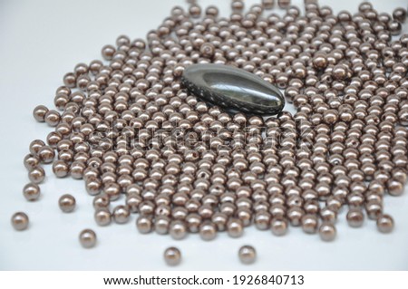 Magnet, oval magnet with bijouterial balls on the side on white background with selective focus in zoom