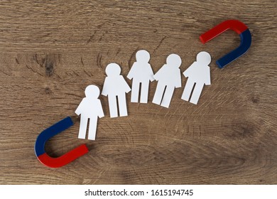 Magnet and paper people on wooden table, flat lay - Shutterstock ID 1615194745