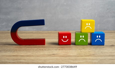Magnet pulling a stack of colorful blocks with sad faces towards a single block with a happy face.