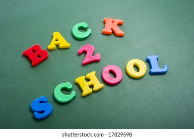 Magnetic alphabet letters on a green chalkboard spelling out Back to School