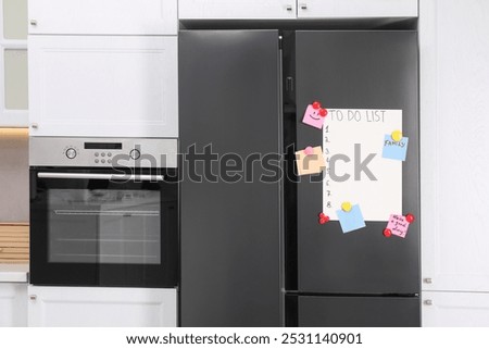 Magnetic board with to do list and notes on refrigerator in kitchen