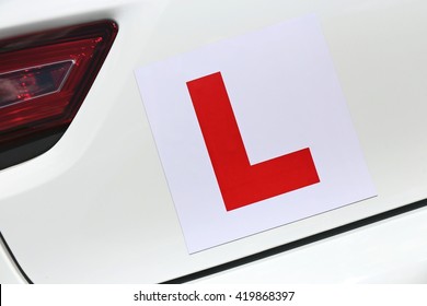 magnetic British L-plate affixed to the back of a white car