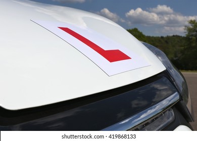 magnetic British L-plate affixed to the front of a white car