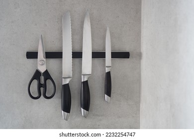 Magnetic knife holder. Magnetic bar for knives. Knives and scissors hang on a magnetic bar in the kitchen. - Powered by Shutterstock