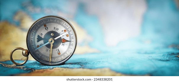 Magnetic old compass on world map.Travel, geography, navigation, tourism and exploration concept wide background. Macro photo. Very shallow focus.