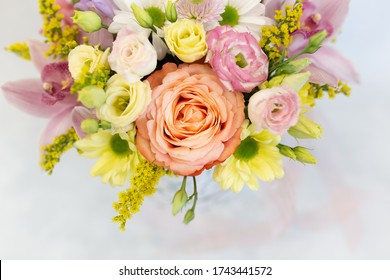 A magnificent bouquet of fresh flowers on a light background (Colors: white, pink, yellow, green. Flowers: rose, eustoma, chrysanthemum, orchid, snapdragon)