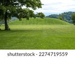Magnificent grass covered indigenous prehistoric burial mound built by people of the Hopewell Culture in present day Ohio. No people, sunny outdoors, with copy space