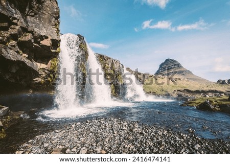 Magnificent Kirkjufellsfoss waterfall with white spray in Iceland.