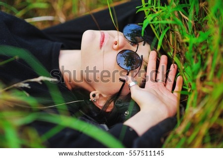 Similar – Junge Frau bedeckt ihr Gesicht vor der Sonne auf einem grünen Feld.