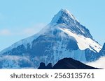 A magnificent snowy mountain peak rises above Hercules Bay on  South Georgia Island.