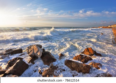 Magnificent Sunset On Mediterranean Sea. Storm Waves Break About Breakwater Stones On Quay. Tel Aviv, Spring