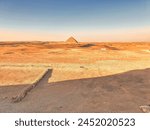 Magnificent view of the Red Pyramid of Snefuru in an other wordly martian-like desert scene as viewed from the entrance to the Bent Pyramid at the Dahshur necropolis near Cairo,Egypt