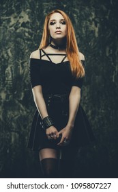 Magnificent woman in black gothic dress over grunge background. Fashion. Gothic style. 