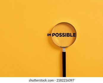 Magnifier focuses on the possible side of the word impossible. It is possible motivational inspirational concept. - Shutterstock ID 2182216397
