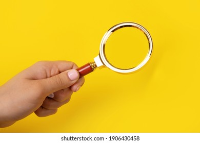 magnifier in hand over yellow background