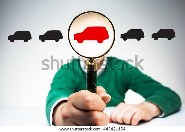 Magnifier with red car\
icon instead of man\'s head on light background with black car\
icons. Concept of\
choice