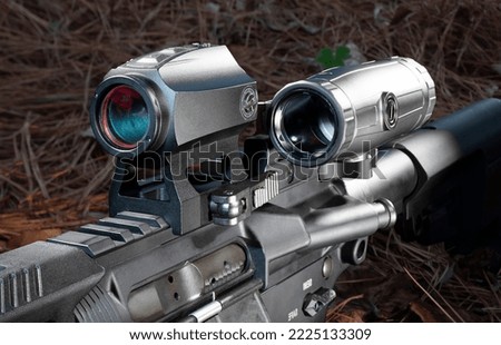 Magnifier to the side of a red dot scope on a modern sporting rifle