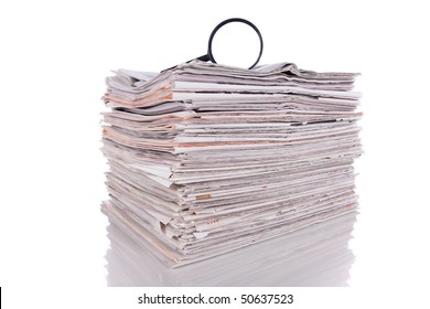 Magnify glass over a stack of newspaper to find fresh information (isolated on white)