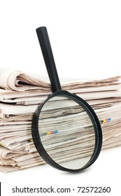 Magnify glass over a stack of newspaper