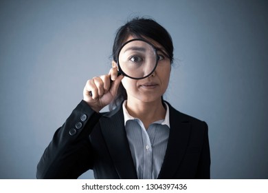 Magnifying glass and businesswoman - Shutterstock ID 1304397436